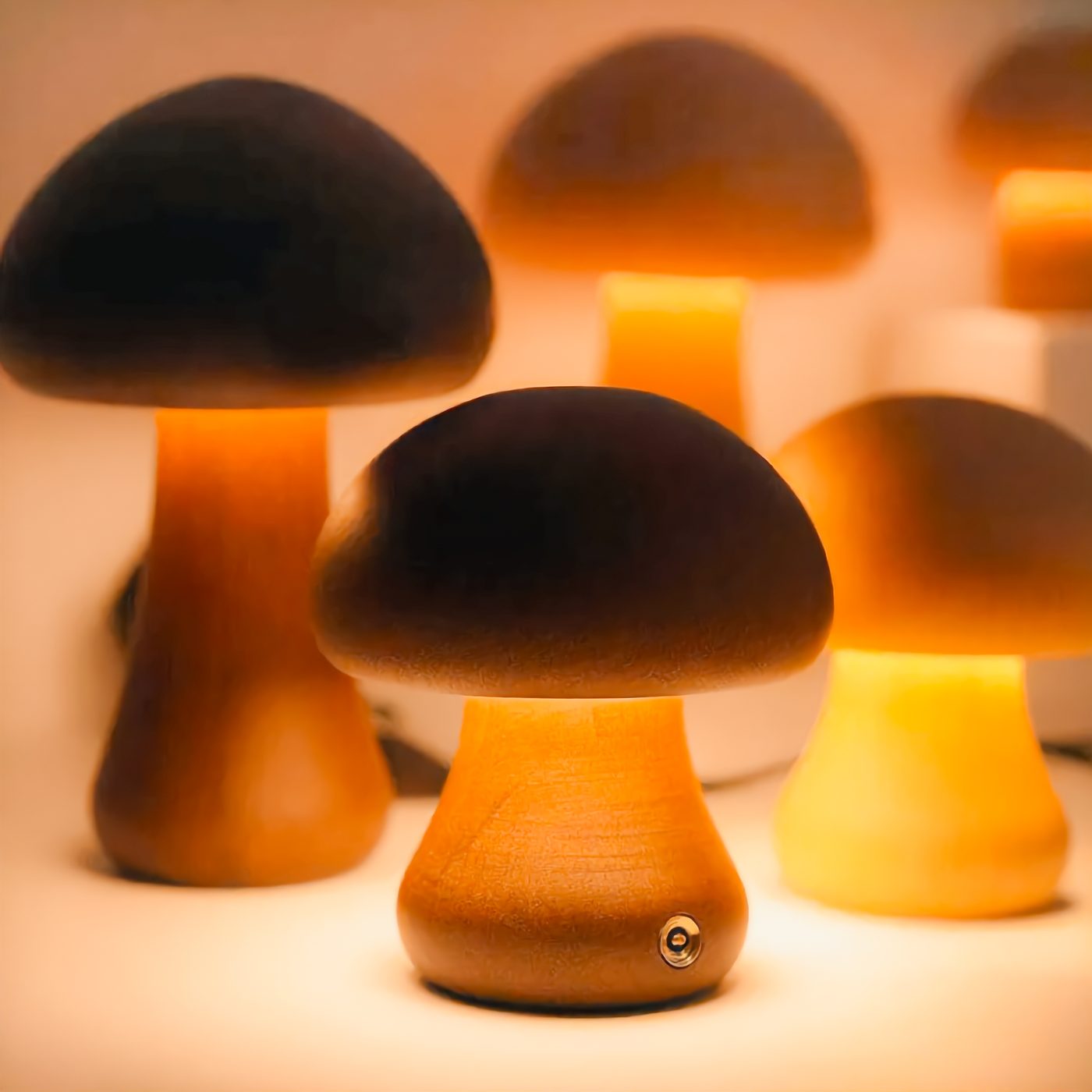 A family of Wooden Mushroom Lights in different sizes and wood finishes glowing together